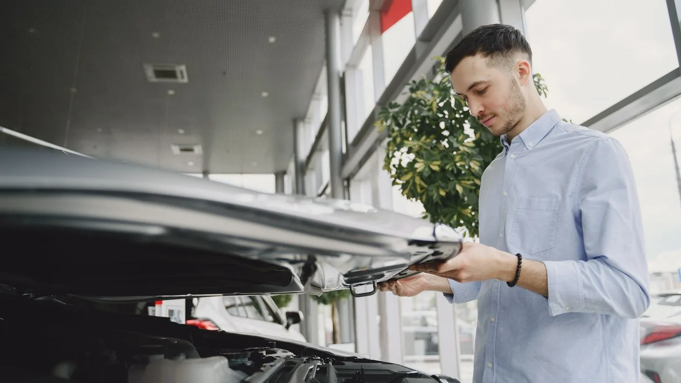 Comprador revisando el motor de un auto usado